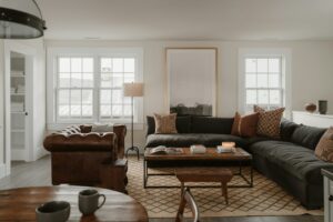 A family compares a sofa and L-shaped sectional in a bright living room with measured walking space.