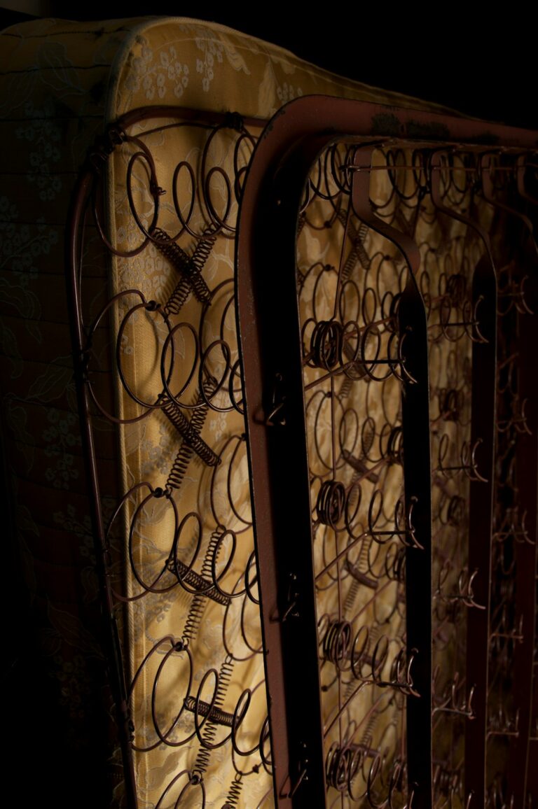 Person inspecting evenly spaced wooden slats and reinforced joints on a sturdy bed frame.